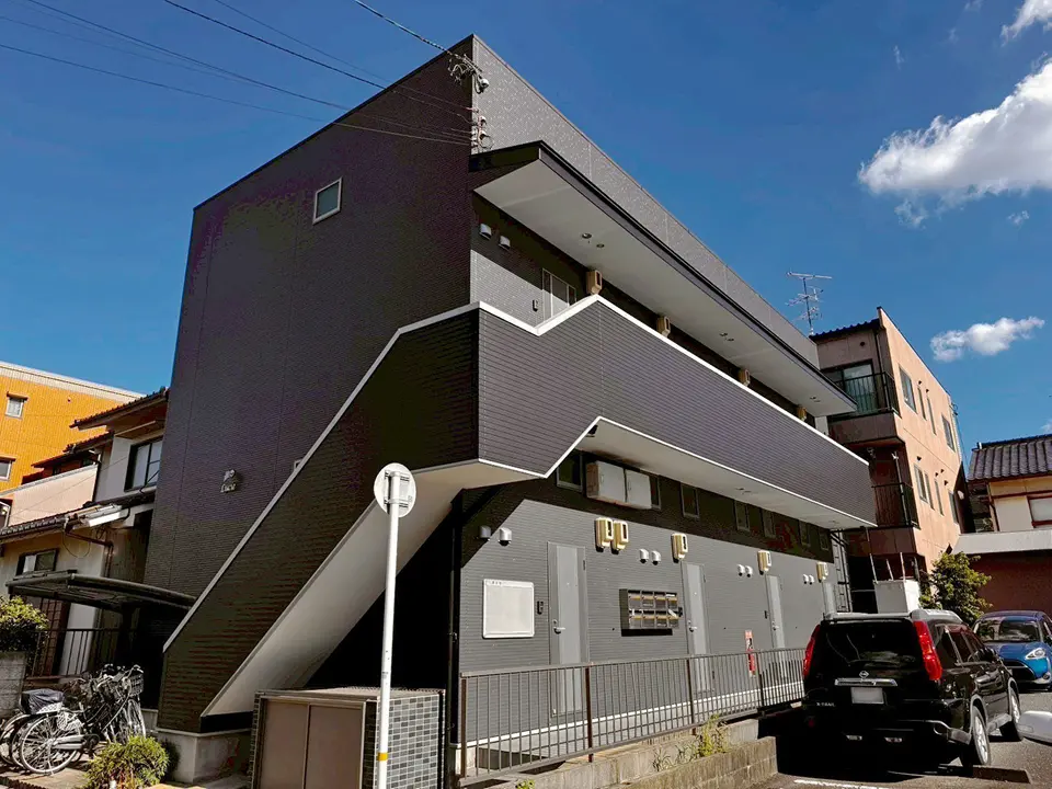 青空の下、直線的なデザインが目を引くアパートの建物全景